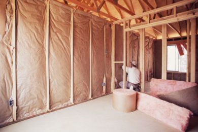 Attic Restoration: Cleanup & Repair Services - Columbus, Ohio. A man installs insulation inside a repaired attic.