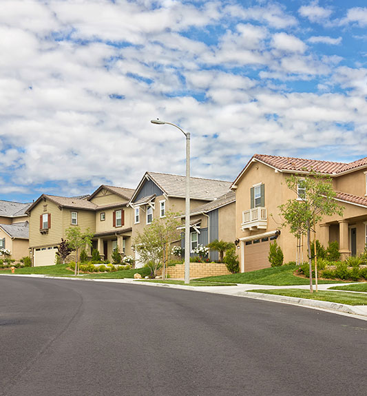 A row of beige houses on a newly paved street